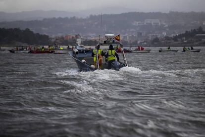 Una lancha del Servizo de Gardacostas se acerca a un grupo de mariscadores en la ría de Pontevedra.