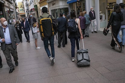 Unos turistas pasean por el centro de Sevilla.