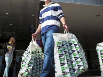 Un hombre carga con dos bolsas de El Corte Inglés en Madrid.