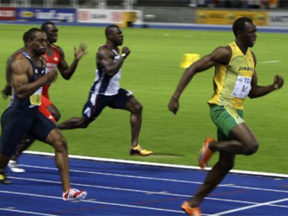 Arriba, Bolt entra en la meta por delante de Gay, segundo, y Powell, tercero. Abajo, celebra su triunfo y el nuevo récord del mundo