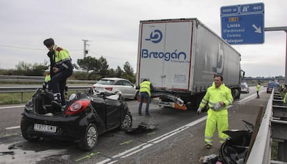 Mossos d'Esquadra y operarios junto al vehículo accidentado