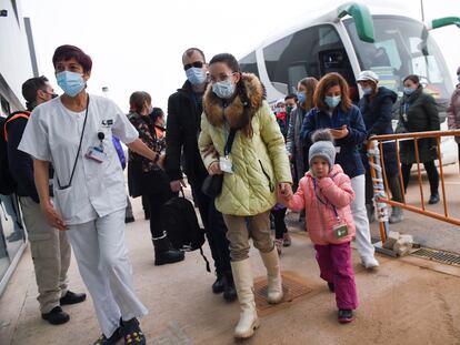 Trabajadores sanitarios reciben un grupo de personas procedentes de Ucrania a su llegada al Hospital Enfermera Isabel Zendal para una revisión médica, el 15 de marzo.