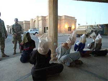 Dos soldados de infantería del Regimiento número 22 de la Cuarta División desplegada en Tikrit, el feudo de Sadam, vigilan a unos detenidos.