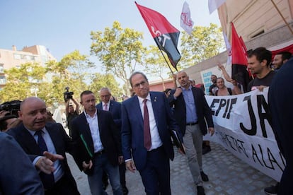 Quim Torra pasa junto a una protesta de profesores en Barcelona.