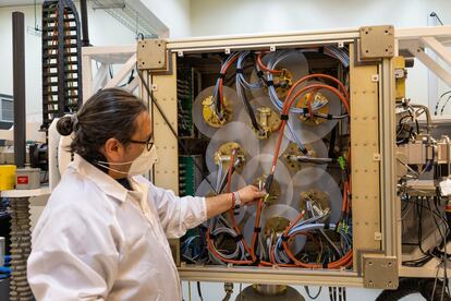 Un trabajador muestra la máquina que recibe las señales de las antenas satelitales.