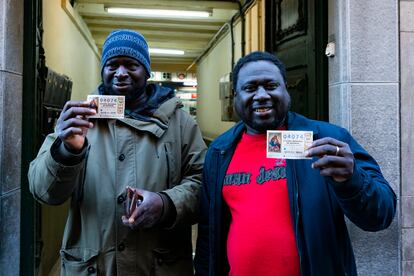 Ibrahim Kanteh, a la derecha, con el décimo premiado en la Lotería de Navidad, en Olot, Girona.