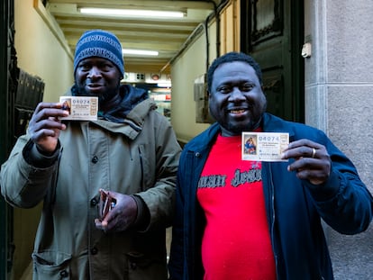 Ibrahim Kanteh, a la derecha, con el décimo premiado en la Lotería de Navidad, en Olot, Girona.