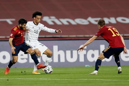 El jugador alemán Leroy Sané controla el balón ante los españoles José Gayá y Dani Olmo, durante el partido de la sexta jornada del grupo 4 de la primera fase de la Liga de las Naciones que las selecciones de España y Alemania disputaron el martes por la noche en el estadio de La Cartuja de Sevilla.