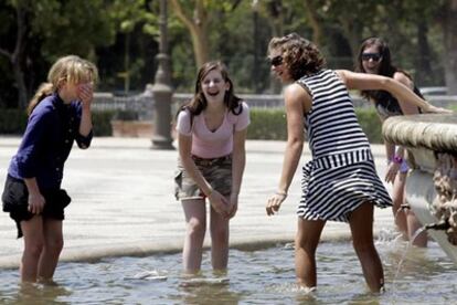 Protección Civil ha alertado a 10 comunidades y a la Ciudad de Melilla por un ascenso en las temperaturas que podrían alcanzar los 43 grados centígrados en algunos puntos de Andalucía. En la fotografía, turistas se refrescan en una fuente de Sevilla.