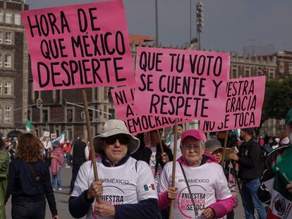 Manifestantes muestran carteles en defensa de la democracia durante la concentración en el Zócalo capitalino.