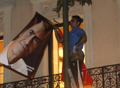 Un operario retira el cartel electoral de Juan Fernando López Aguilar de la sede de la ejecutiva federal del PSOE, en la calle de Ferraz.