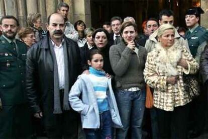 Los familiares de los marineros muertos reciben el pésame del obispo que ha oficiado el funeral.