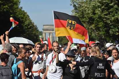 Policial se dirige aos manifestantes em Berlim neste sábado, que reuniu 15.000 pessoas.