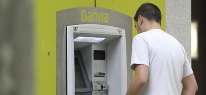 Un hombre saca dinero de un cajero automático de Bankia en Madrid.