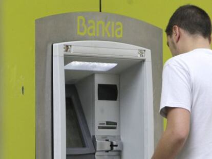 Un hombre saca dinero de un cajero autom&aacute;tico de Bankia en Madrid. 