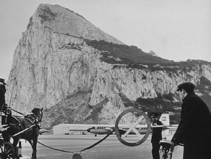 Tráfico en la carretera que lleva de España a Gibraltar, esperando en la barrera a que aterrice un avión, en una imagen de la primera mitad del siglo XX.