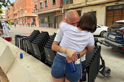 Andrés Eduardo y Leydi Rodríguez, hermano y cuñada de Alejandra, una de las dos víctimas mortales, se abrazan ante la vivienda donde sucedieron lo hechos, este miércoles, en Algemesí.