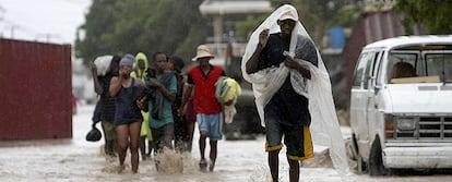 Vecinos de la ciudad haitiana de Gonaives caminan por una calle anegada.