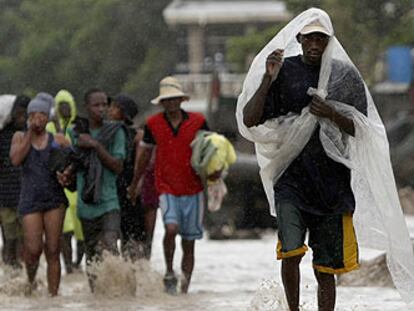 Vecinos de la ciudad haitiana de Gonaives caminan por una calle anegada.