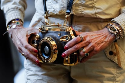 Una asistente al desfile con un luce un bolso y joyas de la marca del desfile de Louis Vuitton, este jueves en el Park Güell de Barcelona.