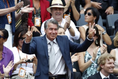 Manolo Santana saluda al público de París. A la derecha, sentado con corbata, Jim Courier, bicampeón en Roland Garros.