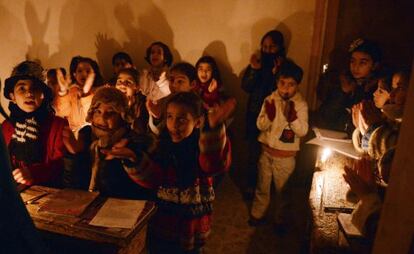 Un grupo de niños sirios atiende una clase con velas ante los cortes de electricidad en Kadi Askar, al norte de Alepo.