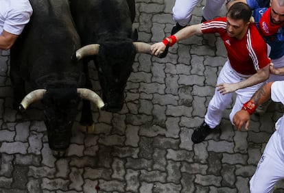Un corredor toca el cuerno de un toro de José Escolar durante el encierro de este sábado.