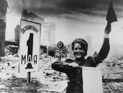 Maria Shalneva, una soldado soviética, en Berlín en 1945 delante de un cartel de celebración del Día del Trabajo.
