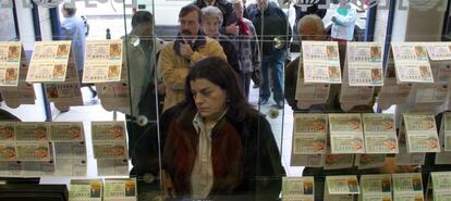 Compradores adquiriendo lotería en la ventanilla de una administración.