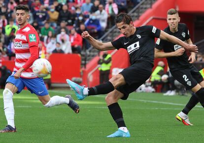 Pere Milla golpea el balón ante Neva, lateral izquierdo del Granada.