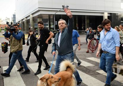 Cerca de 100.000 efectivos militares y de las fuerzas de seguridad custodiaron las 100.185 mesas de votación distribuidas en 14.546 escuelas de todo el país, que estarán abiertas hasta las 18.00 hora local. En la imagen, Alberto Fernández saluda mientras se dirigía a un parque con su perro antes de votar.