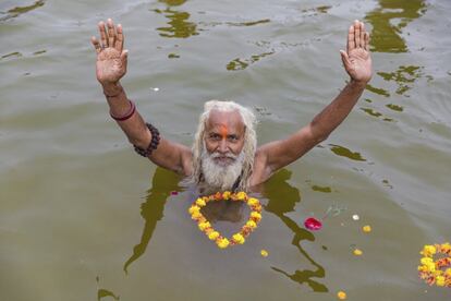 Un hombre santo hindú ofrece oraciones después de los baños rituales en 'Sangam', el punto de encuentro de los ríos sagrados indios del Ganges y el Yamuna, en el auspicioso día de 'Paush Purnima' durante la tradicional feria anual de Magh Mela en Allahabad, India.