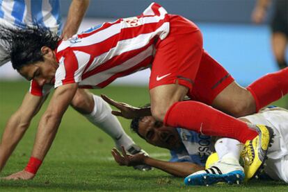 El delantero del Atlético, Radamel Falcao, cae ante el defensa Weligton.