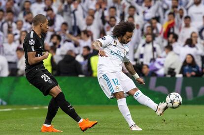 El defensa brasileño del Real Madrid Marcelo Vieira (c) centra el balón presionado por Kylian Mbappé, del Paris Saint Germain.