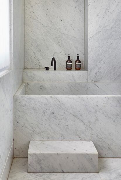 El cuarto de baño está revestido con mármol de Carrara. La bañera, de inspiración japonesa, está realizada a medida. 