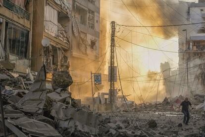 Un hombre corre entre las ruinas de un edificio durante un bombardeo israelí en el barrio de Dahiyeh en Beirut, este viernes. 