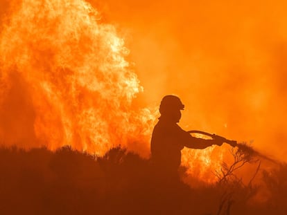 Un bombero participa en las labores de extinción del incendio entre Navalacruz y Riofrío (Ávila), este lunes.