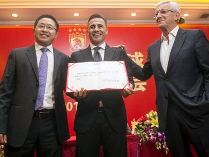 Cannavaro posa con su contrato en las manos, junto a Lippi y un dirigente del Guangzhou.