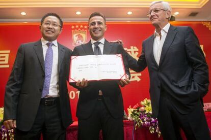 Cannavaro posa con su contrato en las manos, junto a Lippi y un dirigente del Guangzhou.