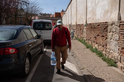 Francisco Brazuelo carga con una garrafa de agua mineral en una de las calles de Toro (Zamora).