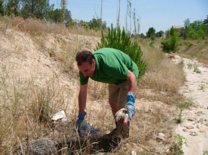 César Redondo recoge basura en la ribera de uno de los pantanos de la Comunidad de Madrid.
