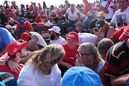 Seguidores de Trump se protegen tras el atentado en Butler. 