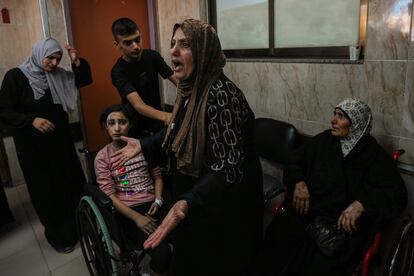 Una mujer palestina grita junto a los heridos de un ataque israelí en el hospital de Al-Aqsa en Deir al Balah, este domingo.