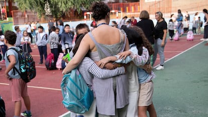 Una maestra se abraza a sus alumnas en el patio de un colegio de Madrid en el primer día de clases 2023-2024.