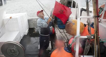 Un marinero iza la bandera marroquí en el pesquero 'Fontanilla'.