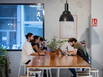 Jóvenes trabajan en la cafetería del espacio de 'coworking' Itnig del barrio del Poblenou de Barcelona.