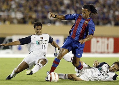 Ronaldinho se lleva el balón ante Fernando y Honda.