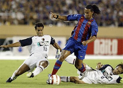 Ronaldinho se lleva el balón ante Fernando y Honda.