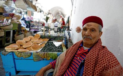 Un vendedor ambulante posa con un machmoum, un ramo de jazmín, detrás de la oreja, en el souk Kasbah del casco antiguo de Túnez.