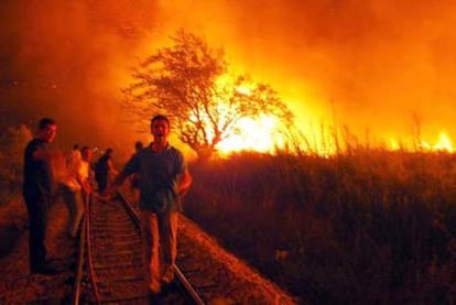 Varios bomberos y voluntarios tratan de acabar con las llamas en un incendio forestal en la región de Argólida, al sur de Grecia, en 2007.